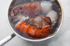 cooked lobsters are being prepared in a pot with ice and water on the side