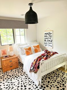 a white bed sitting in a bedroom next to a black and white checkered floor