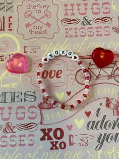 a couple of bracelets sitting on top of a table next to a heart shaped object