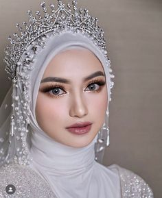 a woman wearing a white hijab with pearls on her head and veil over her head