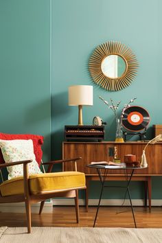 a living room with two chairs and a table in front of a mirror on the wall