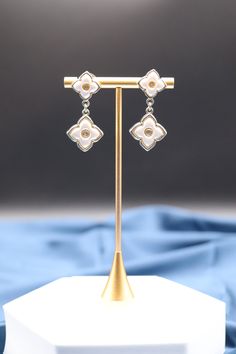 Dangling Pearl Gold Clover Earrings feature delicate clover-shaped pendants adorned with lustrous pearls that gently sway with your movements, adding a touch of elegance and charm to your attire. These earrings are a symbol of luck and sophistication, making them a graceful choice for special occasions or everyday wear. Length: 1.73” Width: 0.79” Closure: Pushed Back Material: Brass with 18K Gold Plating with Rhodium Coating Lead Free and Hypoallergenic Adjustable Silver Bracelet, Clover Earrings, Halloween Sale, Cz Diamond, Blue Gemstones, Gold Pearl, Ruby Red, Adjustable Bracelet, Gemstone Colors