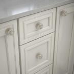 a white bathroom vanity with marble top and drawers