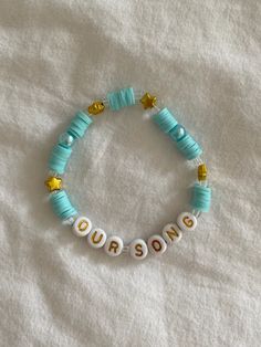 a beaded bracelet with the word oursie written on it and gold stars in white letters