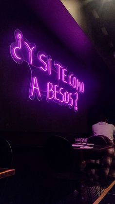 a purple neon sign that says, site com a beso? on the wall