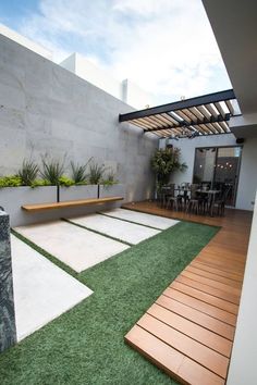 an outdoor patio with grass and wooden benches