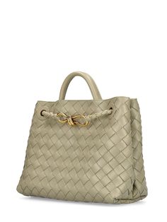 Find BOTTEGA VENETA Andiamo Leather Top Handle Bag on Editorialist. The BOTTEGA VENETA Andiamo bag features a woven leather construction, a knotted gold-tone clasp, a top handle, and a detachable shoulder strap. The bag also has a magnetic closure, two internal pockets, and one internal zip pocket. It measures 22cm in height, 25cm in width, and 10.5cm in depth. The strap drop is 50cm, and the top handle drop is 8cm. Formal Satchel Bag With Intrecciato Weave, Evening Woven Leather Handheld Bag, Elegant Woven Leather Shoulder Bag For Travel, Formal Intrecciato Weave Shoulder Tote Bag, Elegant Woven Leather Tote Shoulder Bag, Elegant Woven Leather Travel Bag, Elegant Shoulder Bag With Braided Round Handles, Formal Intrecciato Weave Tote Shoulder Bag, Designer Shoulder Bag With Intrecciato Weave