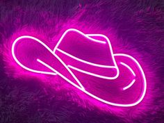 a neon cowboy hat sitting on top of purple fur