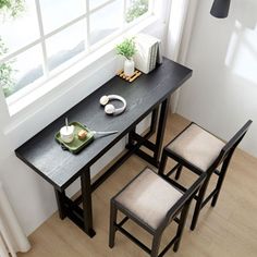 three chairs and a table in front of a window