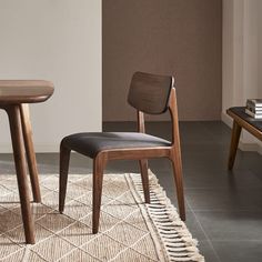 two wooden chairs sitting next to each other on top of a rug