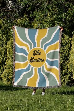 a blanket that says the smiths on it in front of some grass and bushes