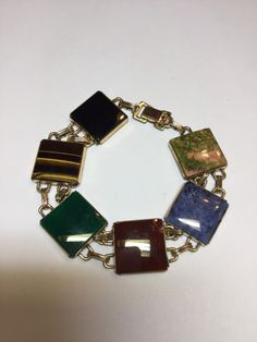 "This bracelet from the 1950's. An alternative to the scarab bracelet. The bracelet is marked WRE 1/20 12kgf on the fold over catch. There is some wear on the back of the catch. It has all genuine stones, onyx, green and black, carnelian, tiger eye, agate and sodalite. Each stone measures 5/8\". There is some minor surface scratching on the stones from everyday wear. It measures 7 1/2\" long. Any questions, please email me." Eye Agate, Scarab Bracelet, 2024 Wishlist, The Catch, Hand Ring, The Fold, Moonstone Ring, Fashion Books, Chain Link Bracelet