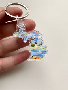 a person is holding a key chain with the state of michigan on it