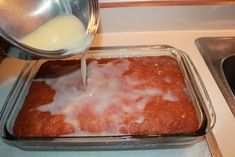 someone pours milk into a baking dish on the stove