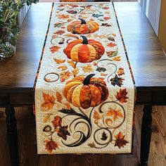 a table runner with pumpkins and leaves on it