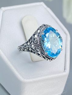 Natural Sky Blue Topaz Ring - Sterling Silver Filigree Iris Design#201 Custom Made This is a stunning Art Deco/Edwardian reproduction in 925 sterling silver filigree with a Natural Sky blue topaz gemstone. The 3.32ct natural sky blue is 13mm in long by 9mm wide. The ring is 16mm North to South on the finger. The inside of the band is marked 925 for sterling silver. Notice the beautiful craftsmanship of the filigree floral setting. This is an ornate and detailed ring. This is a lovely reproductio Handmade Blue Topaz Fine Jewelry Ring, Handmade Blue Topaz Ring In Fine Jewelry Style, Anniversary Turquoise Topaz Ring Stamped 925, Blue Oval Topaz Ring Stamped 925, Handmade Blue Topaz Ring In Sterling Silver, Handmade Blue Topaz Ring For Formal Occasions, Blue Filigree Ring Hallmarked, Blue Hallmarked Filigree Ring, Blue Topaz Filigree Ring