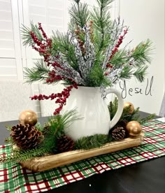 a white coffee cup filled with pine cones and greenery