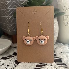 a pair of earrings with a teddy bear on it