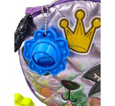 two plastic toys are sitting in front of a purse with a crown on the top