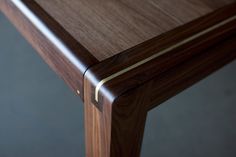 a close up view of a wooden table with gold lines on the top and bottom