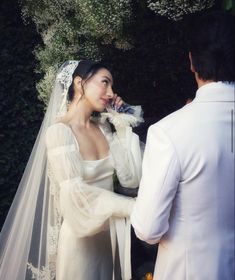 a woman in a wedding dress standing next to a man