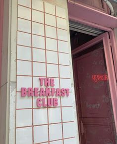 the breakfast club sign is pink and white tiles on the building's front door