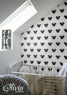 a baby's room decorated in black and white with mickey mouse decals on the wall