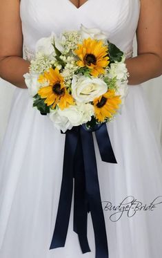 a bride holding a bouquet of sunflowers and white roses