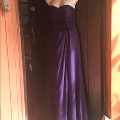 a purple dress is hanging on a door