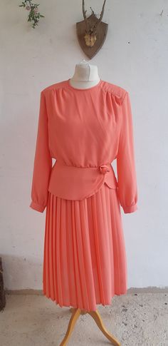 "Vintage 1980's coral pink dress by Eastex the dress has a peplum waist band that is elasticated, there is a rose on the waist band, the dress has a pleated skirt bottom. the dress is shoulder padded  100% polyester and has a button fastening on the bodice . Size Medium M condition: very good vintage condition Bust 40\" Waist (unstretched 32\") (stretched 40\") Length 44\" Please Visit my new ETSY shop which specialises in vintage mens clothing and accessories BidandBertVintageMen.etsy.com All of my items are genuine vintage so signs of wear are to be expected, if there any obvious issues with the garments that I can see I will photograph and explain them to you as best I can. If you are in anyway unhappy with the purchase please do get in touch and I will do my very best to resolve any is Pink Pleated Skirt Dress For Formal Occasions, Pink Pleated Formal Dress, Formal Pink Pleated Dress, Pink Midi Pleated Dress, Spring Pleated Vintage Dress For Formal Occasions, Pink Fitted Dress With Accordion Pleats, Fitted Pink Pleated Dress With Pleated Bodice, Fitted Pink Dress With Accordion Pleats, Summer Pink Pleated Dress