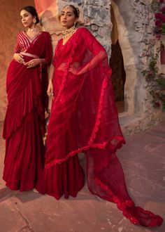 This gorgeous red drape sari in georgette with crinkle detailing is paired with fully embroidered sequins and beaded blouse. The blouse is padded, have side zip closure and have a flattering v-neck line. The outfit is paired with embroidered belt. Red Georgette Pre-draped Saree With Sheer Dupatta, Red Pre-draped Saree With Sheer Dupatta In Dola Silk, Evening Anarkali Blouse In Georgette, Chanderi Sharara For Evening, Bollywood Style Red Sharara For Evening, Red Bollywood Sharara For Evening, Red Bollywood Style Sharara For Evening, Red Georgette Blouse Piece For Navratri, Evening Anarkali Traditional Wear In Georgette