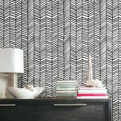 a black and white wallpaper with an abstract design in the corner, next to a dresser