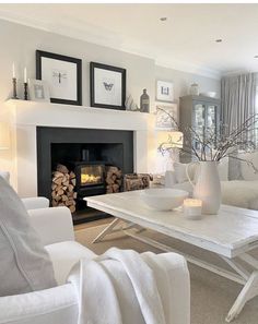 a living room filled with furniture and a fire place in front of a white fireplace