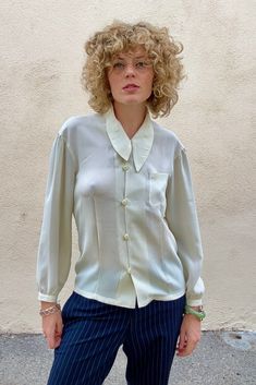 Vintage Matsuda White Shirt With Asymmetrical Collar in wonderful condition. This semi-sheer creamy button down is elegant with vintage flair. A timeless beauty. Comfortable and versatile. Made in Japan. dry clean only. 100% polyester. Best fits size S/M. Approx Measurements: Underarm to underarm: 17" across Length: 25" Classic Cream Formal Shirt, Elegant Summer Blouse With Spread Collar, Classic Formal Cream Shirt, Semi-formal White Silk Blouse, White Silk Blouse For Semi-formal Occasions, Chic Cream Collared Shirt, Cream Formal Shirt With Spread Collar, Elegant Beige Shirt With Spread Collar, Formal Cream Spread Collar Shirt