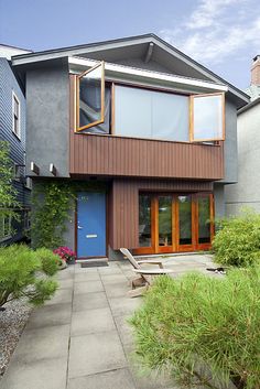 a modern house with wood siding and blue door