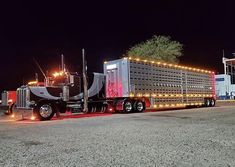 a large semi truck with lights on it's sides parked in a parking lot