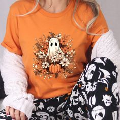 Retro Ghost T-shirt, Vintage Floral Ghost Halloween T-shirt, Flower Halloween Shirt, Cute Ghost Shirt, Retro Fall Shirt, Vintage Ghost Tee Welcome to NoordesignBySelin!🌟 Thank you for visiting our shop! We hope you find something that adds a little extra warmth and beauty to your day. 😊 Happy Shopping! 🛒 📢 Important Details: Check All Photos: Review all images for product details. 📸 Choose Size & Color: Select your T-shirt size from the drop-down list next to the item picture. For color opt Spooky Orange T-shirt For Fall, Spooky Long-sleeve Orange T-shirt, Spooky Orange Long Sleeve T-shirt, Spooky Long Sleeve Orange T-shirt, Orange Spooky T-shirt For Fall, Spooky Orange Fall T-shirt, Orange Halloween T-shirt With Funny Print, Halloween Funny Print Orange T-shirt, Spooky Orange Graphic Print T-shirt