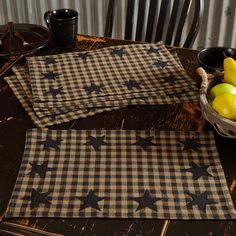 two placemats with black stars on them sitting on a table next to some fruit