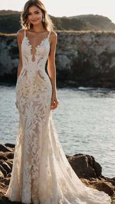 a woman in a wedding dress standing by the water