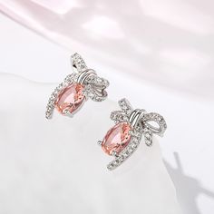 Romantic, enchanting and compassionate, the gentle pink blush of morganite creates a sense of calm and reflects the happier aspects of life. Inspired by vintage designs, these lovely earrings are crafted in sterling silver and showcase a beautiful bow with diamonds for a touch of sparkle. A wonderful gift or well earned treat for yourself.Carat Weight: 2.3 ctStone Size: 6*8 mmNumber of Stones: 2 Stone Shape: OvalStone Color: Fancy PinkCarat Weight: 0.934 ctStone Size: 1.3,1.1 mmStone Type: Jeuli Elegant Blush Earrings, Elegant Pink Sterling Silver Crystal Earrings, Pink Round Crystal Earrings For Formal Occasions, Elegant Oval Peach Jewelry, Feminine Pink Earrings For Anniversary, Elegant Peach Oval Jewelry, Pink Sterling Silver Earrings Perfect For Her, Pink Sterling Silver Earrings For Her, Pink Sterling Silver Earrings As Gift For Her