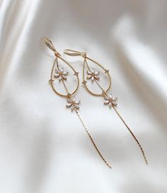 Our long elegant bridal earrings are the perfect addition to any wedding ensemble. Made with high-quality gold plated components and sparkling cubic zirconia, they add a touch of minimalistic, yet statement-worthy glamour. Elevate your look and make a subtle yet stunning statement with these earrings. - Handcrafted in my PA studio - Earrings measure 4.25 inches - Available in rose gold, yellow gold and rhodium (silver) - Handcrafted in the US. - Nickel free and hypoallergenic - PLEASE ALLOW APPR Diamond Chandelier Earrings In Yellow Gold For Wedding, Yellow Gold Diamond Chandelier Earrings For Wedding, Wedding Chandelier Earrings In Yellow Gold With Diamonds, Wedding Yellow Gold Diamond Chandelier Earrings, Single Dangle Diamond Earring For Wedding, Delicate Diamond Drop Earrings For Wedding, Dainty Dangle Diamond Earrings For Wedding, Delicate Cubic Zirconia Bridal Earrings For Pierced Ears, Delicate Single Diamond Earring For Wedding