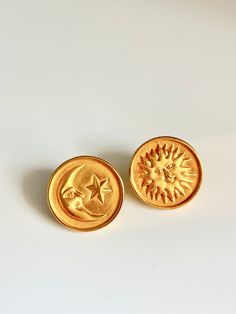 two gold buttons with the moon and star on them are sitting next to each other