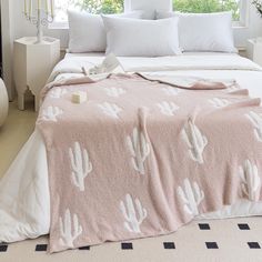 a bed with a pink blanket and white pillows