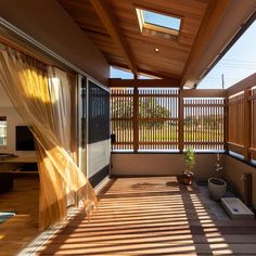 the sun shines through sheer curtains on an outdoor patio with wood slats and sliding glass doors