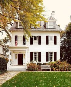 a large white house with black shutters on the front