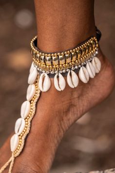 Dhye is a fashionable foot chain that makes a bold statement. With an adjustable string, gold beads and cowrie shells, it is both lightweight and eye-catching. Perfect for a beach vibe or grounding activity, Dhye is your go-to accessory for the goddess in you.  adjustable (fits all sizes)  material: gold beads, faux le Foot Chain, Cowrie Shells, Cowrie Shell, Beach Look, The Goddess, Beach Vibe, Gold Beads, Daenerys Targaryen, Shells