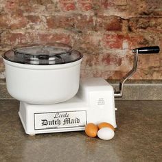 two eggs are sitting on the counter next to an old style blender and egg beater