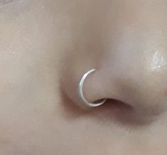 a close up view of a nose with an open nose ring on it's side