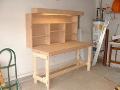 a wooden workbench sitting in the middle of a room next to a ladder