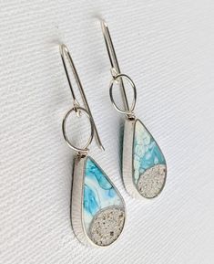 These dangle teardrop earrings with real sand and hand colored eco resin, mixed with crushed stones and silver specks and poured/painted individually. Each earring measures approx. 1.25 inch high and hangs at about 1.75 inches from the ear. The body and wiring is made with Sterling Silver. Made to order option, Please allow 10-14 days while I make this earrings especially for you. Slight variations in color and sand shapes are expected since all my work is handmade by me one piece at a time - I Unique Teardrop Resin Earrings, Handmade Resin Teardrop Jewelry, Unique Teardrop Earrings, Turquoise Teardrop Hand Painted Earrings, Turquoise Teardrop Hand-painted Earrings, Turquoise Hand Painted Teardrop Earrings, Eco Resin, Crushed Stone, Pouring Painting